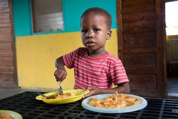 Kind beim Essen im Heim des Oeuvre St. Francois auf der Ile a Vache