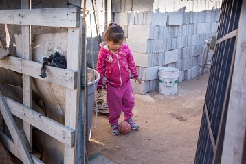 Spielendes Kind im Neubaugebiet für Migrantenfamilien in der Wüste am Stadtrand von Ciudad Juarez.