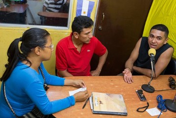 Orlando Machado von JOC Venezuela spricht bei einem Interview in der Radiostation des Marktes "Las pulgas" in Maracaibo; mit dabei Parmenides Alemán alias "Varón", ein Lastenträger, und Elena Marchán von JOC Venezuela.